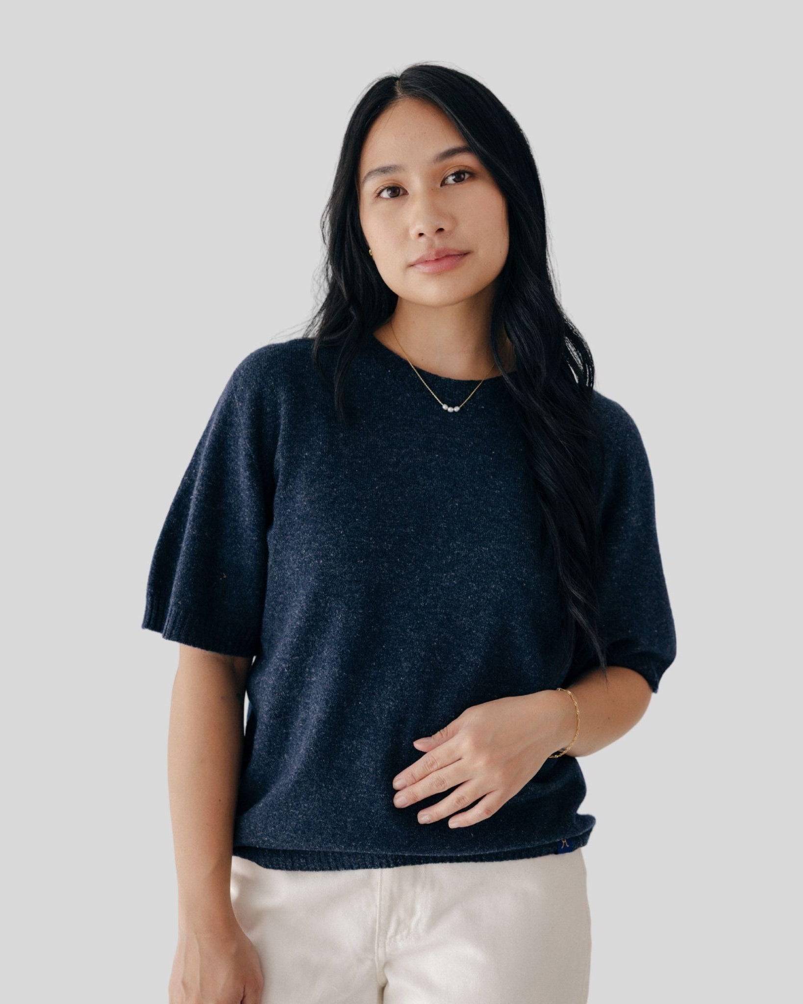 Woman wearing a dark blue shirt against a plain background