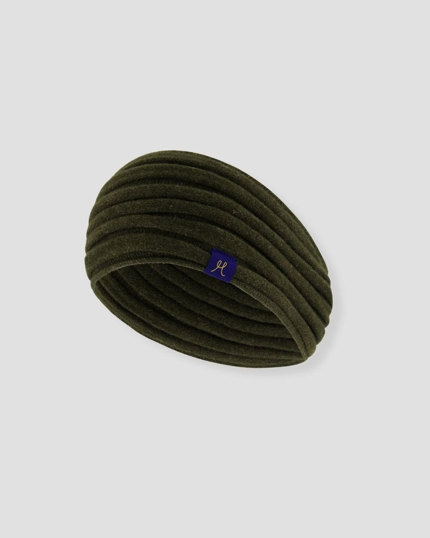 Green headband with a small logo on a light gray background