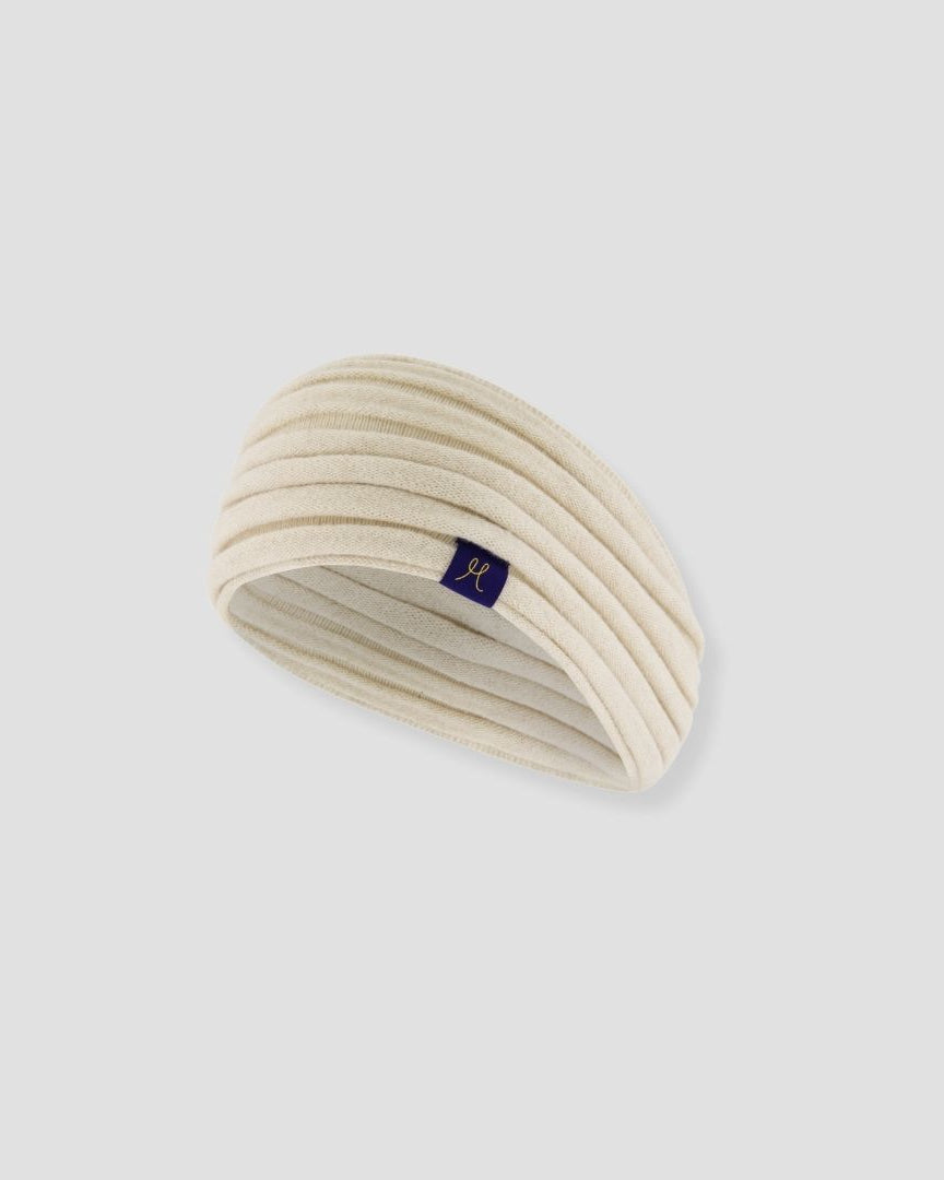 Beige headband with a small logo on a light gray background