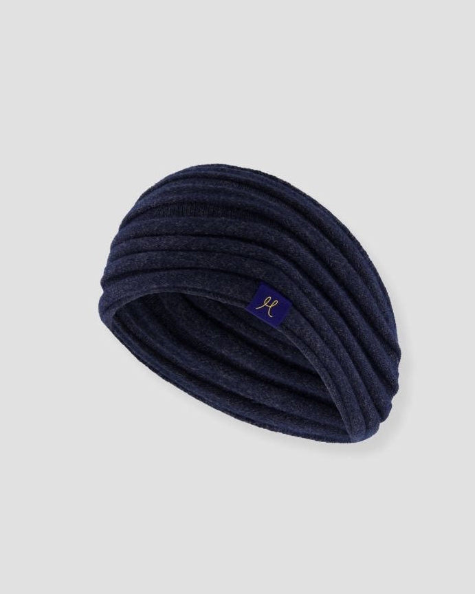 Navy blue knitted headband with a brand logo on a light gray background