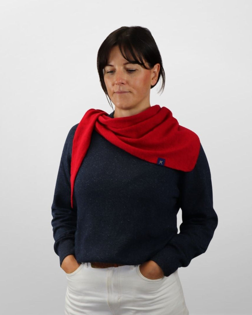 Woman wearing a red scarf and dark sweater on a white background