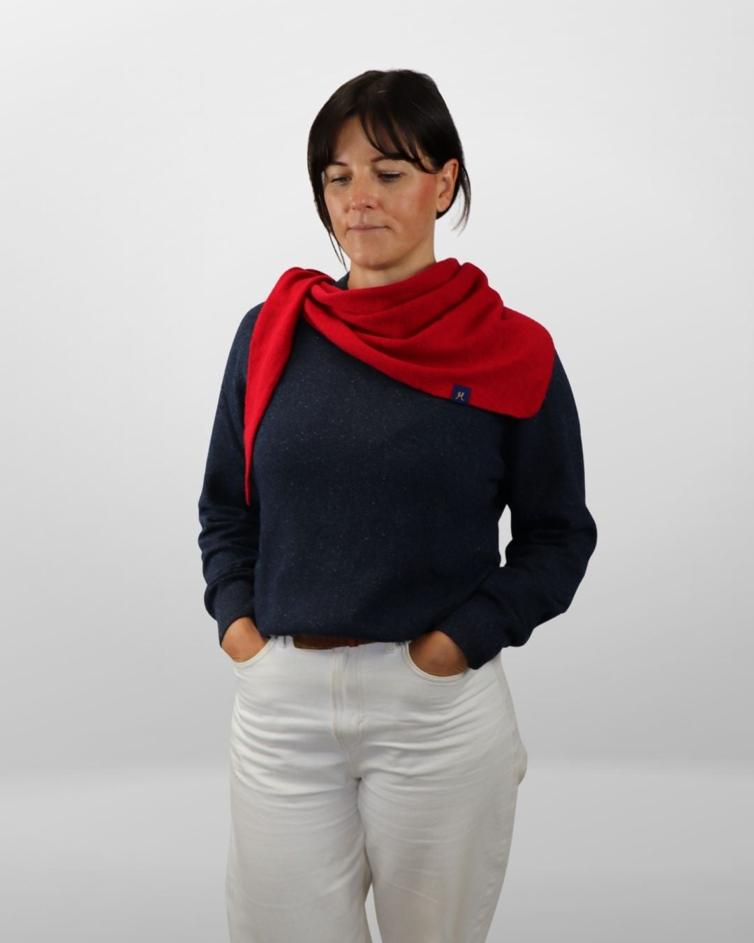 Woman wearing a red scarf and dark sweater on a white background