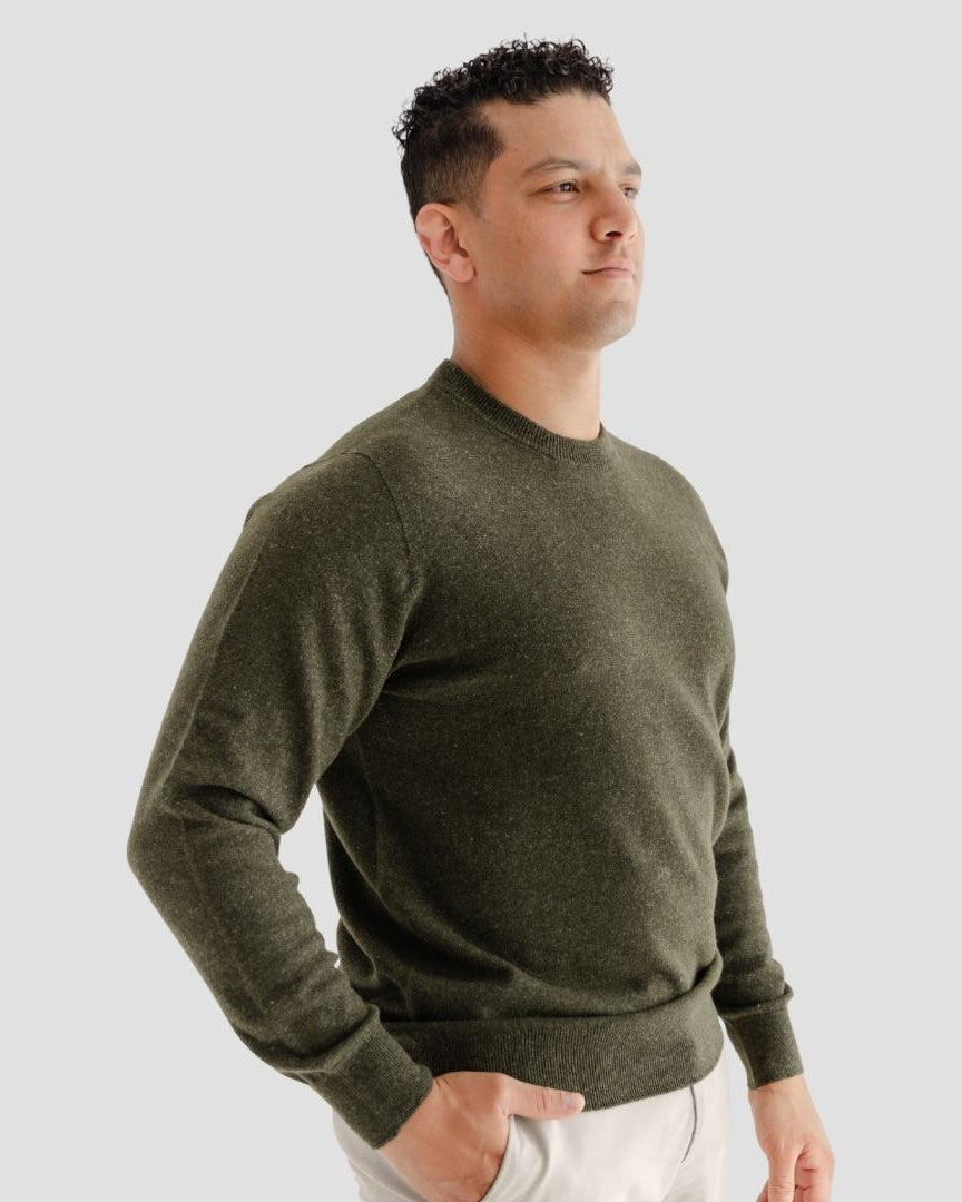 Man wearing a green sweater against a plain background