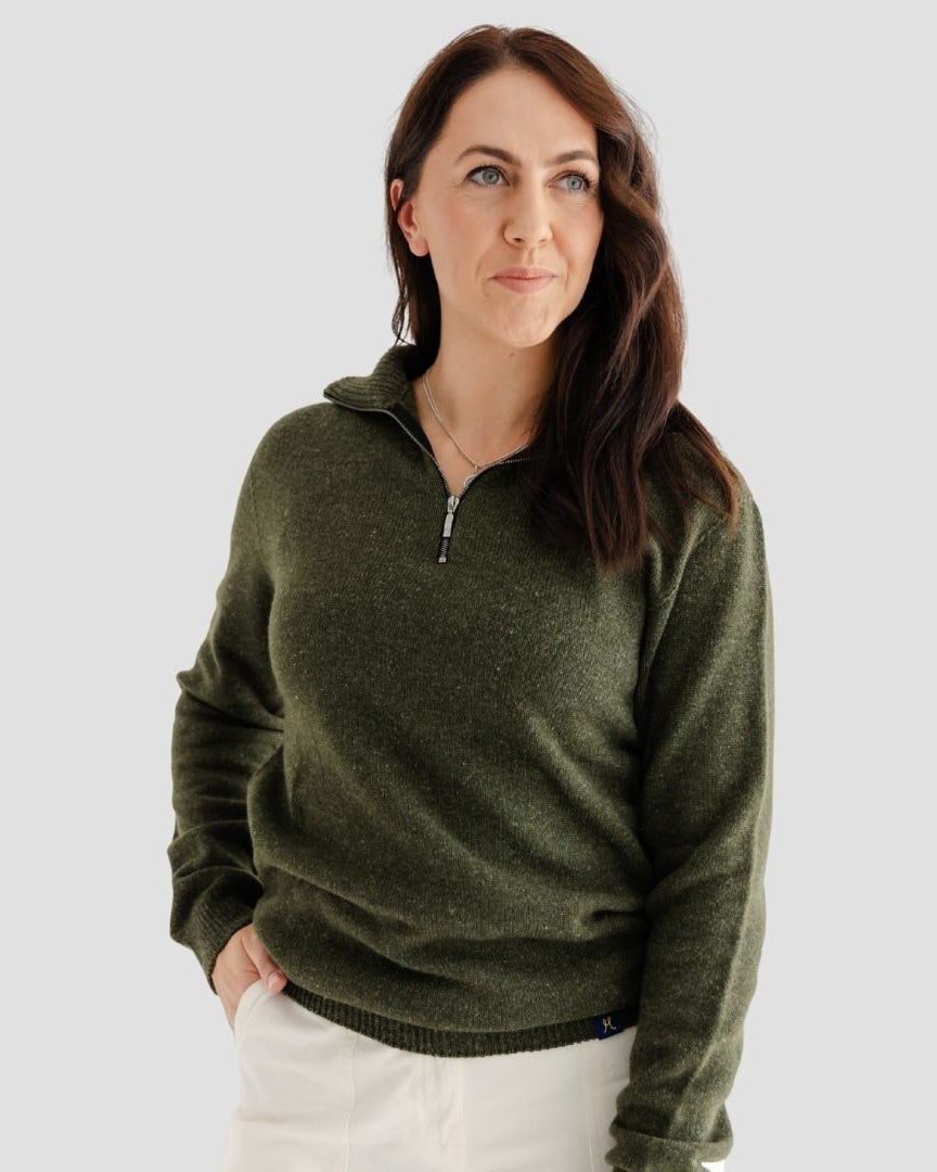 Woman wearing a green sweater against a plain background