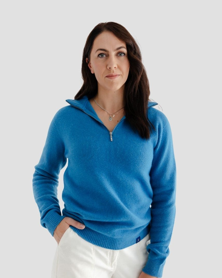 Woman wearing a blue sweater against a light gray background