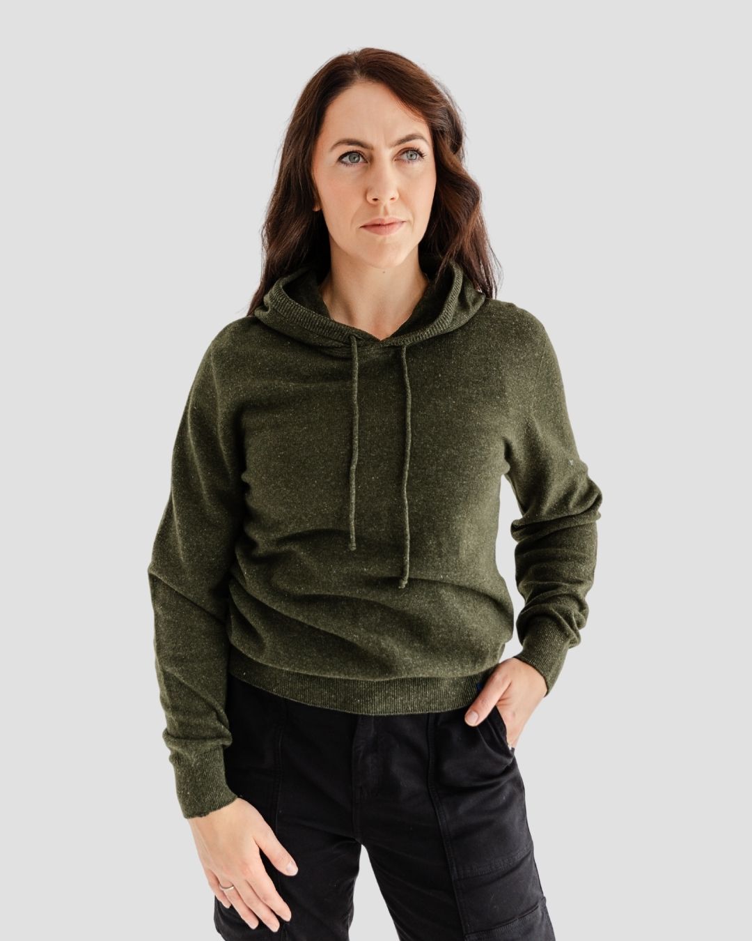 Woman wearing a green hoodie against a plain background