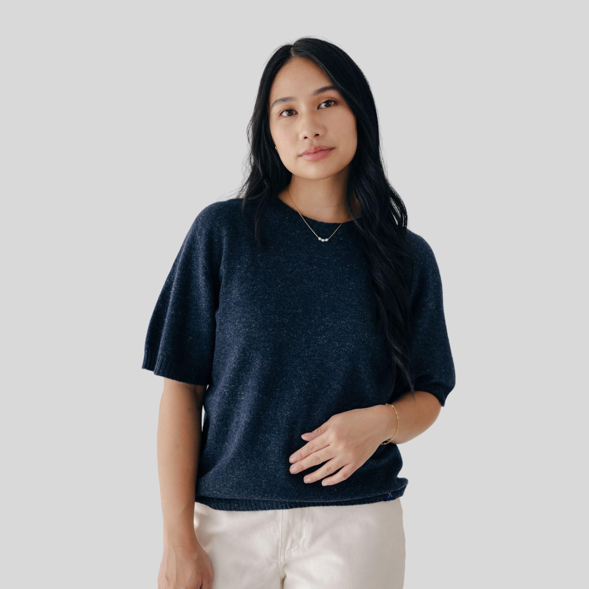 Woman wearing a dark blue shirt against a plain background