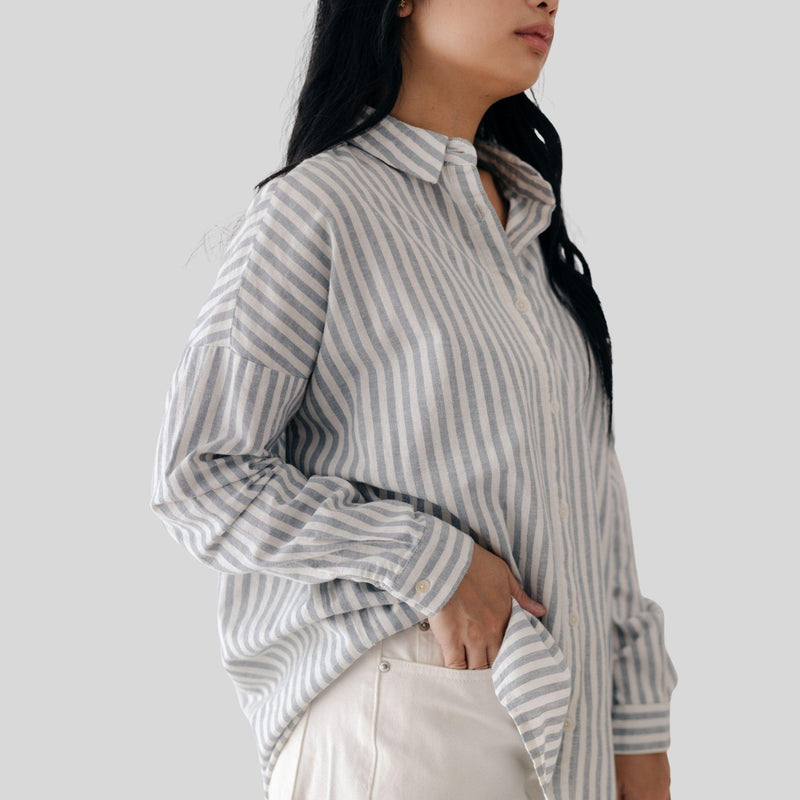 Person wearing a striped shirt with a plain background