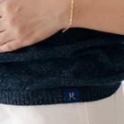 Navy blue sweater with a brand logo on a white background
