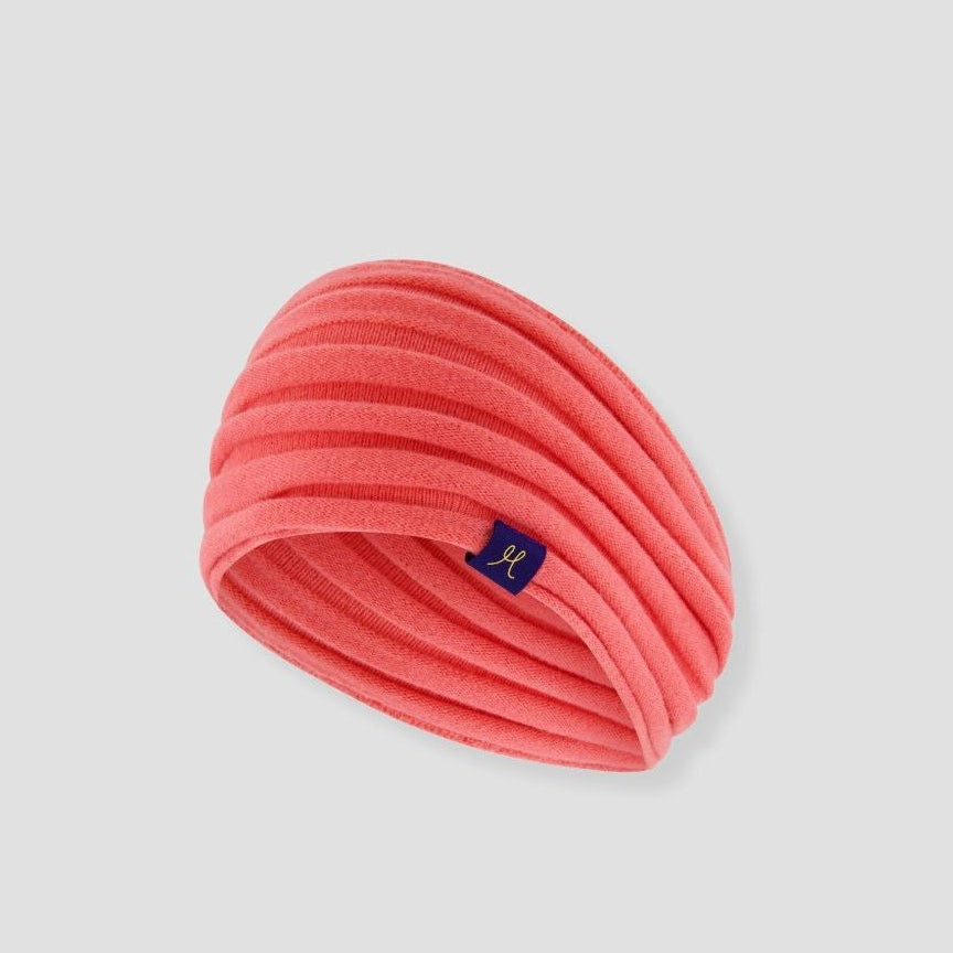 Pink headband with a brand logo on a light gray background