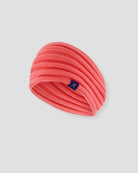 Pink headband with a brand logo on a light gray background