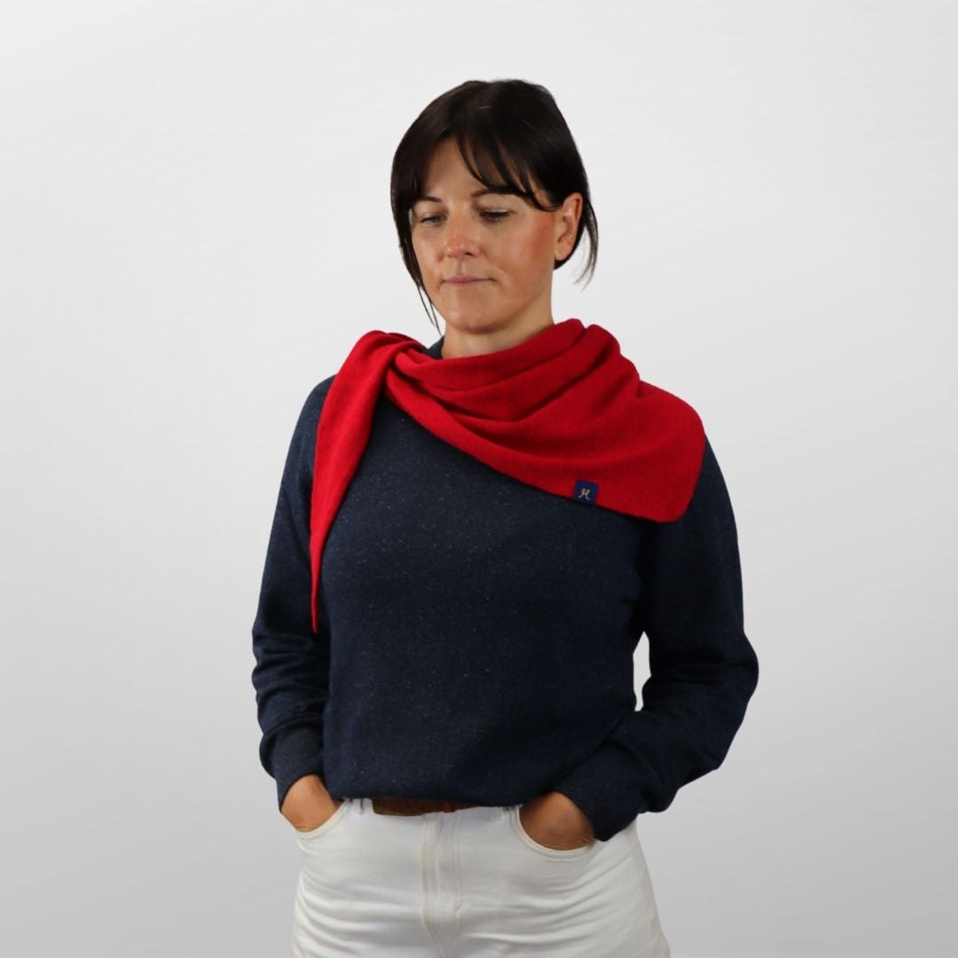 Woman wearing a red scarf and dark sweater on a white background