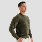 Man wearing a green sweater against a plain background