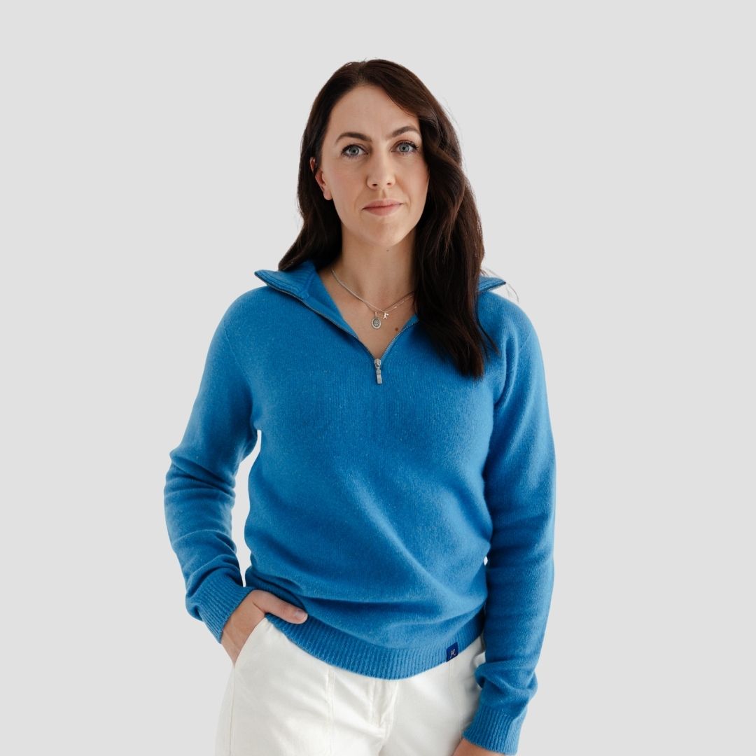 Woman wearing a blue sweater against a light gray background