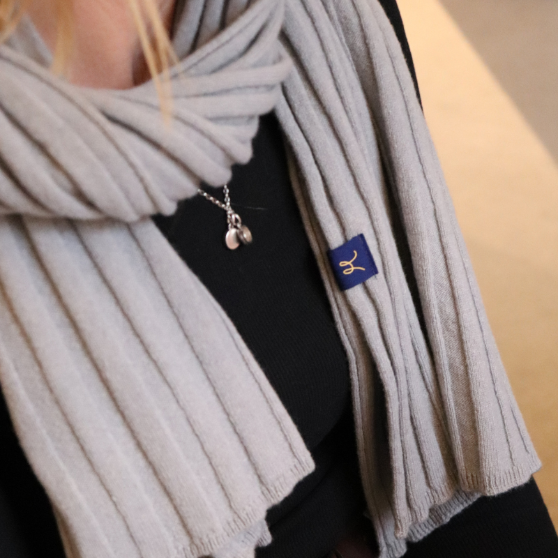 Grey rib knit scarf wrapped around ladies neck 