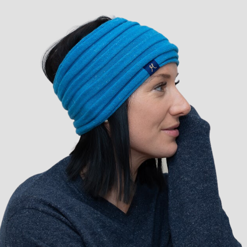 Lady wearing bright blue headband in ribknit style and a navy v - neck sweater made from hemp and merino.