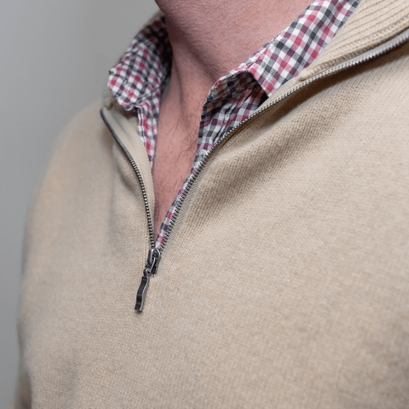 Man wears beige quarter zip jumper 