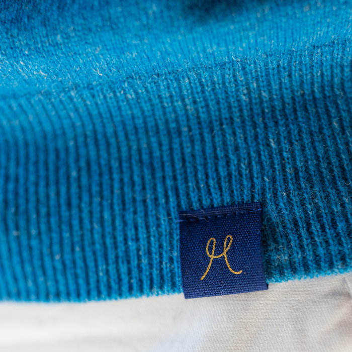 Hemprino label detailing shows the recognisable H on waistband of bright blue V-neck jersey.
